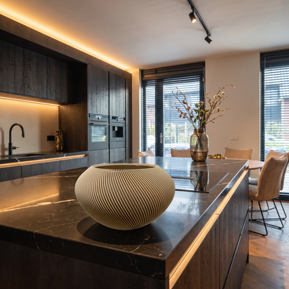 Gedraaide decoratieschaal als luxe woondecoratie op een modern kookeiland